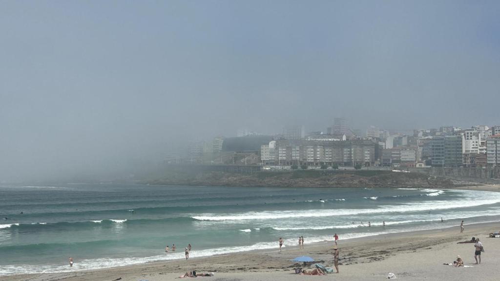 Una repentina niebla sorprende a los bañistas de las playas de Riazor y Orzán en A Coruña