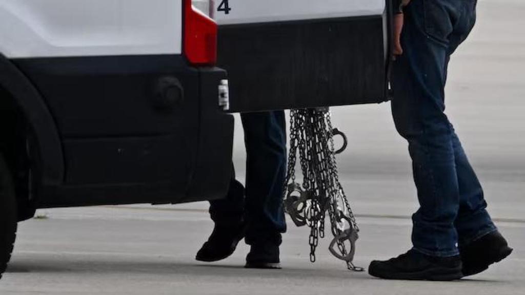 Esposas retiradas a migrantes detenidos antes de abordar un avión tras ser trasladados desde un centro de ICE, en el aeropuerto de Gary, Indiana, el 20 de junio de 2025.