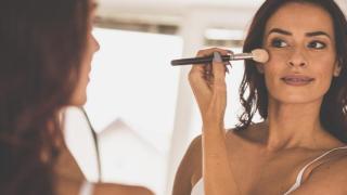 Mujer aplicándose colorete.