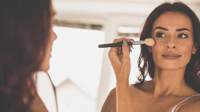 Mujer aplicándose colorete.
