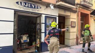 Los Bomberos de Zaragoza trabajando en uno de los negocios afectados por el reventón de la tubería