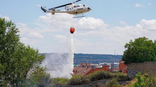 Efectivos terrestres y aéreos luchan contra un incendio junto al Hospital de León