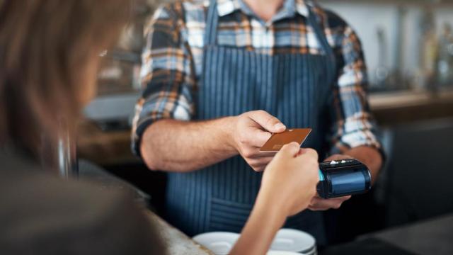 Cliente pagando la cuenta a un camarero.