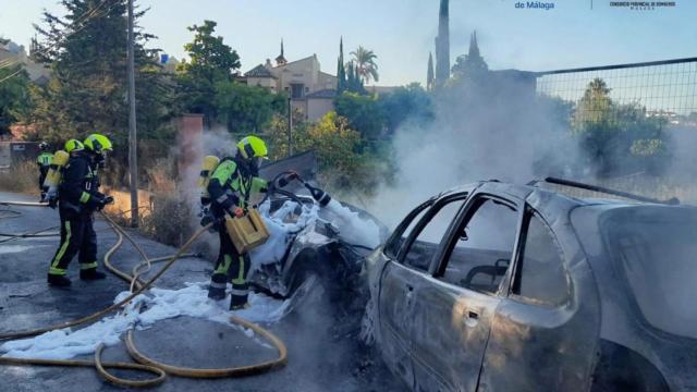 Efectivos del Consorcio Provincial de Bomberos de Málaga sofocan las llamas tras la colisión de dos turismos en Estepona.
