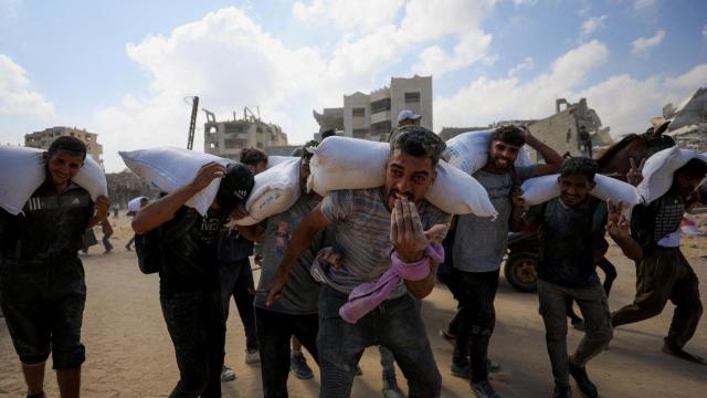 Palestinos transportan ayuda humanitaria que entró en Gaza a través de Israel.