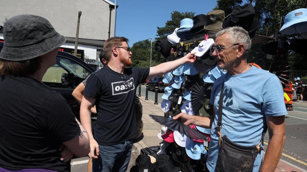 Un fan de Oasis sostiene un sombrero a la venta antes del show de Oasis en Heaton Park. Foto: Reuters / Temilade Adelaja.