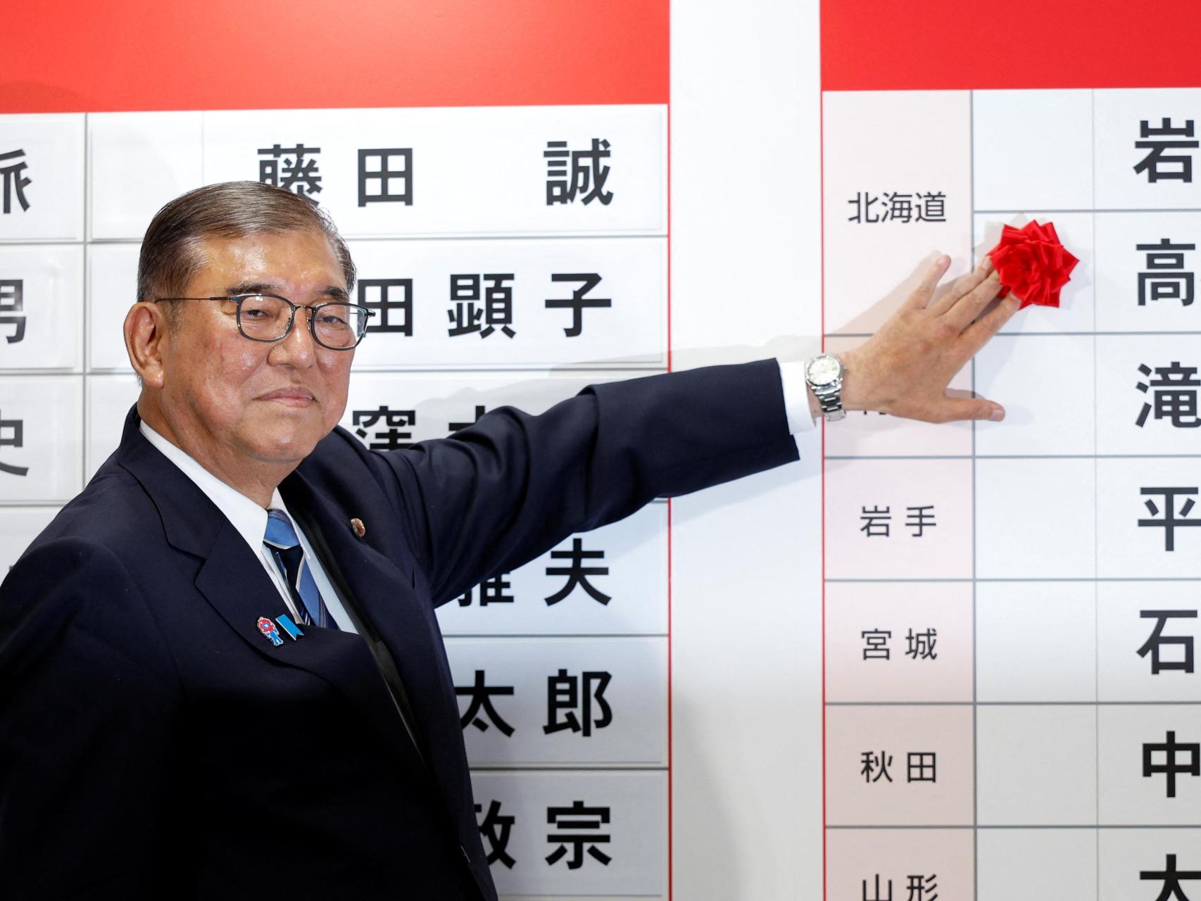Shigeru Ishiba, primer ministro de Japón y presidente del gobernante Partido Liberal Democrático (PLD), coloca una rosa roja de papel sobre el nombre de un candidato electo en la sede del PLD, el día de las elecciones para la Cámara Alta, en Tokio, Japón, el 20 de julio de 2025.
