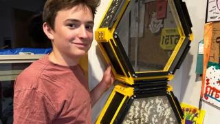 Oliver Taylor, de 13 años, junto con la colmena instalada en su cuarto.