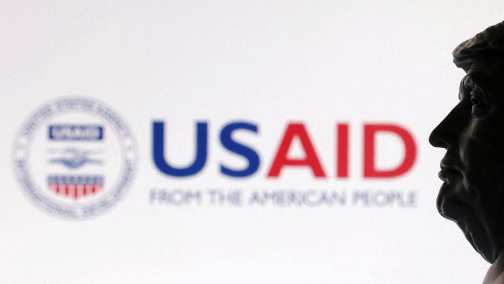 Una impresión 3D del presidente Donald Trump fotografiada junto al logo de USAID.