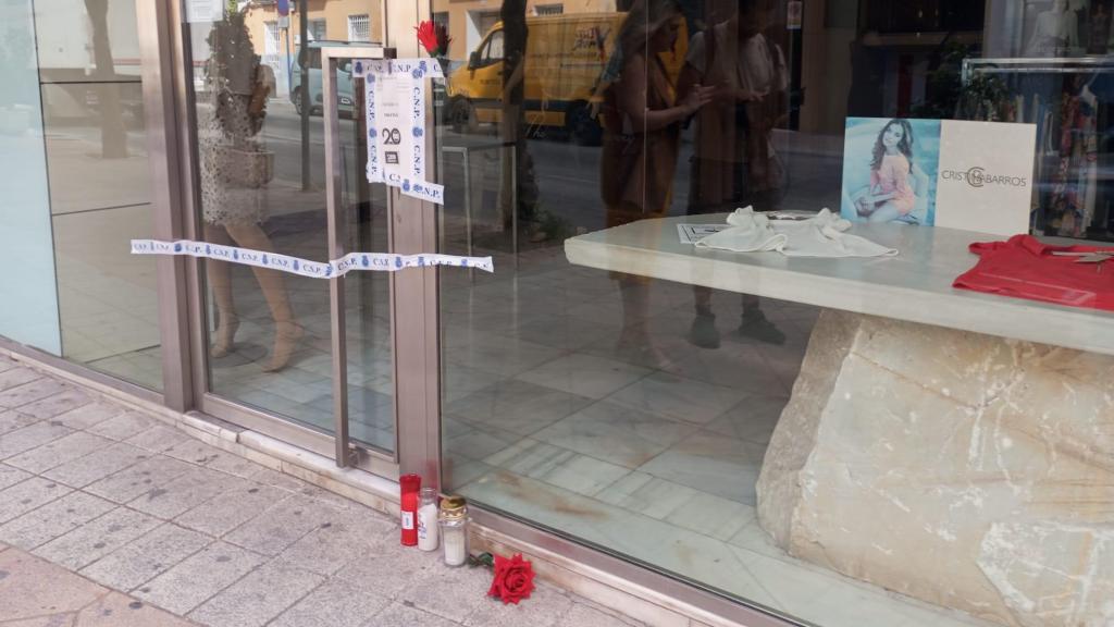 El escaparate de Tejidos Hernández en Molina de Segura, este martes, precintado por la Policía Nacional y con velas en recuerdo del difunto Felipe.