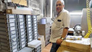 Antonio González, entre cajas llenas de cuchillos afilados y una máquina afiladora en el local de Las Burgas en la avenida de Finisterre.