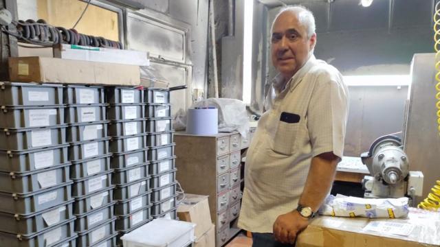 Antonio González, entre cajas llenas de cuchillos afilados y una máquina afiladora en el local de Las Burgas en la avenida de Finisterre.