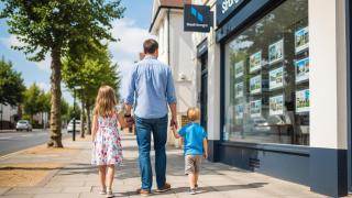 Imagen generada con IA de un padre con dos hijos delante de una agencia inmobiliaria.