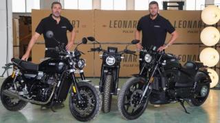 Los hermanos Marc (i) y Jordi Llorens (d) posan con tres modelos de sus motos Leonart.