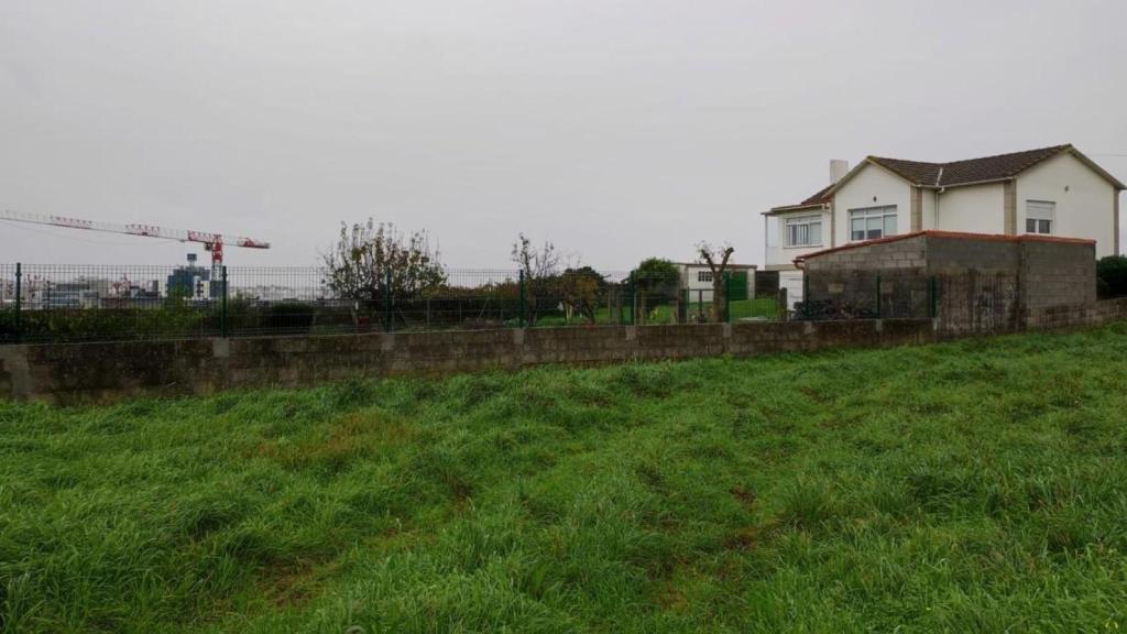 Una vivienda de Monte Mero y, al fondo, una grúa de construcción en Xuxán.