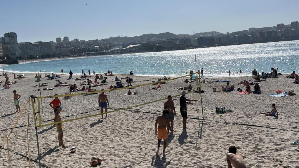 Varios coruñeses practicando deporte en la playa de Orzán.
