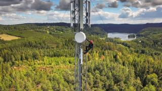 Un operario trabajando en una antena de telefonía en una zona rural.