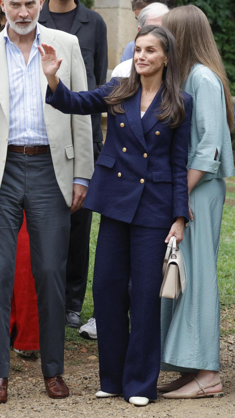 La Reina  ha elegido un look en azul y blanco.