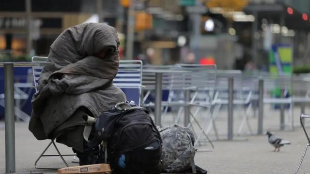Una persona sin hogar sentado en un banco de Nueva York.