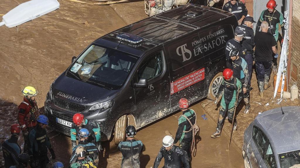Buzos y un furgón fúnebre salen de un garaje inundado en la dana. Rober Solsona / EP