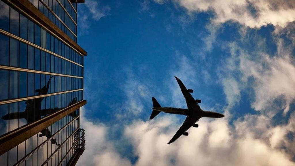 Un avión sobrevolando edificios.