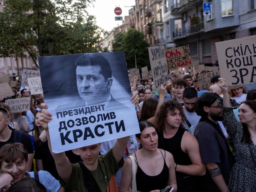 Un manifestante porta una pancarta con el rostro de Zelenski y un mensaje: El presidente permitió robar
