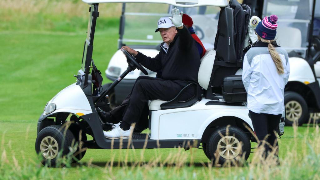 Trump saluda a la prensa este domingo desde su carrito de golf en el 'Trump Turnberry resort'