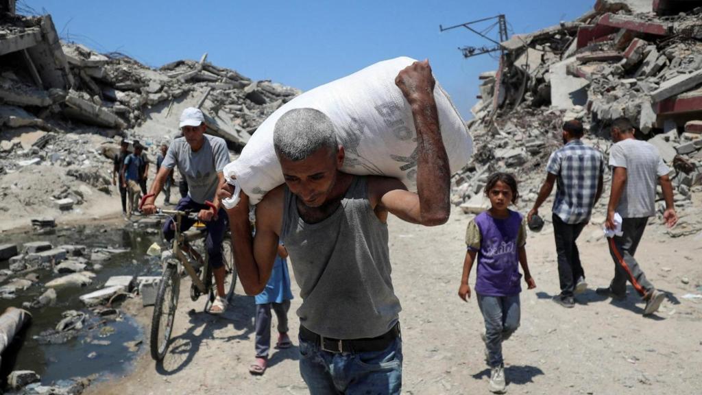 Un ciudadano palestino cargando con un saco de la ayuda humanitaria.