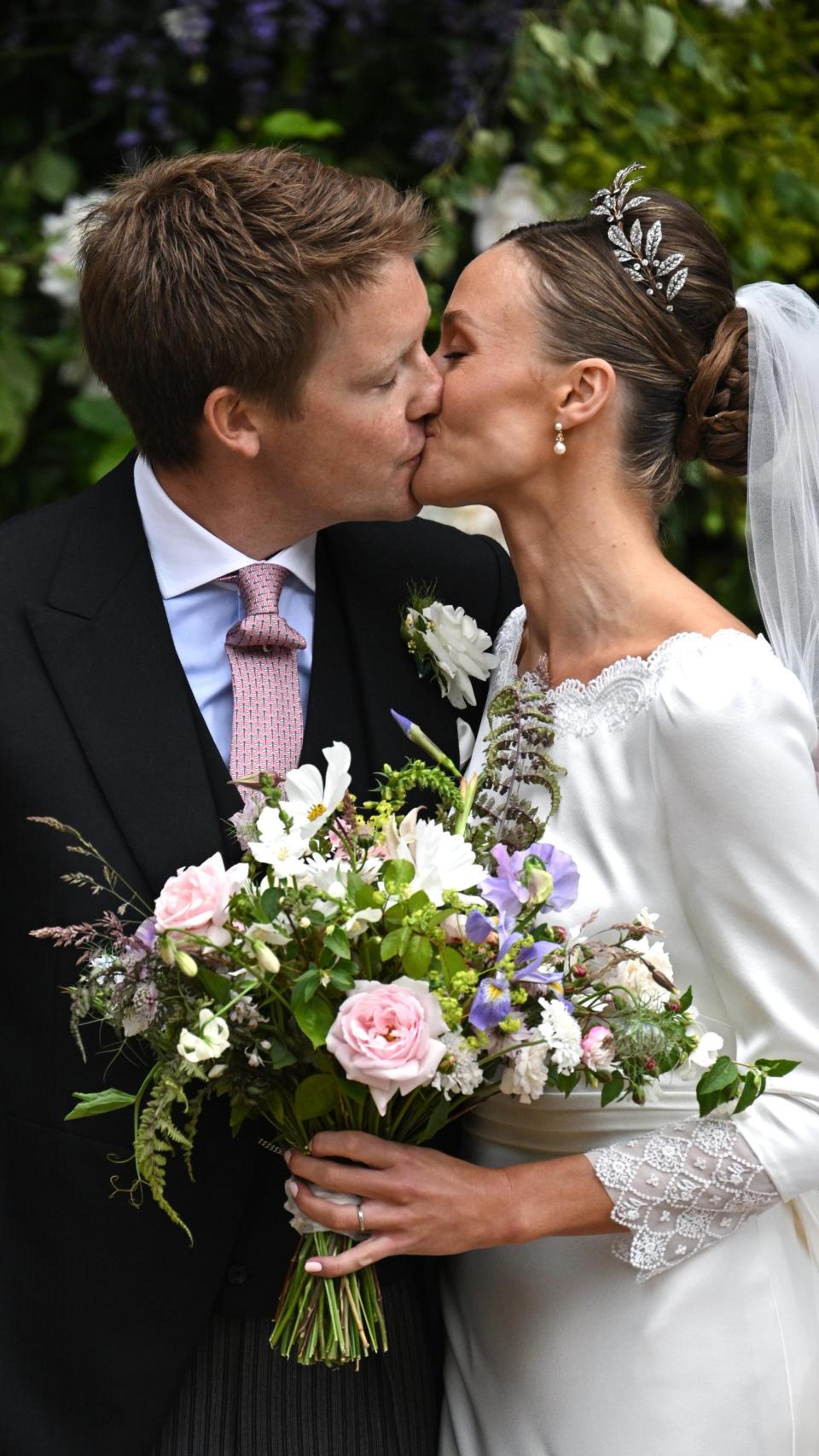 El matrimonio, besándose apasionadamente el día de su 'sí, quiero'.