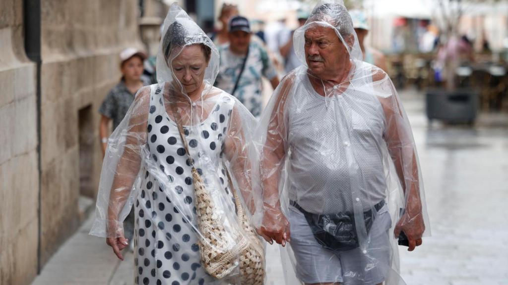 Dos personas tras las lluvias de la semana pasada en Valencia
