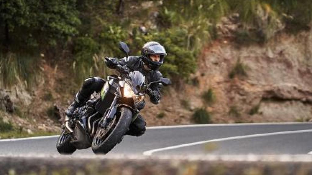 Un motero circulando por carretera.