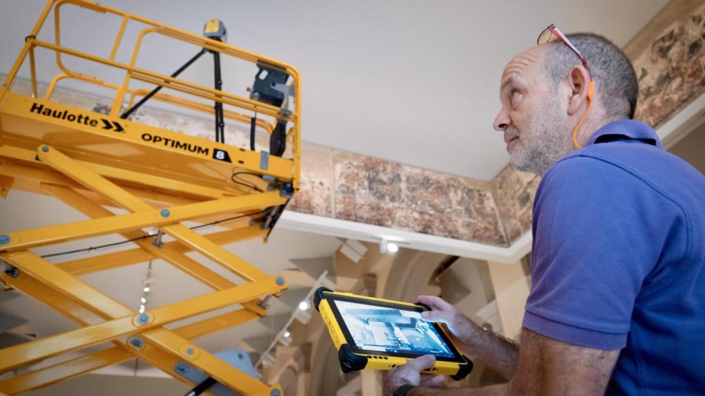 Uno de los miembros del equipo técnico aragonés estudia las condiciones de las pinturas murales de Sijena, este lunes en el MNAC. Foto: EFE/Fabian Simon/Gobierno de Aragón