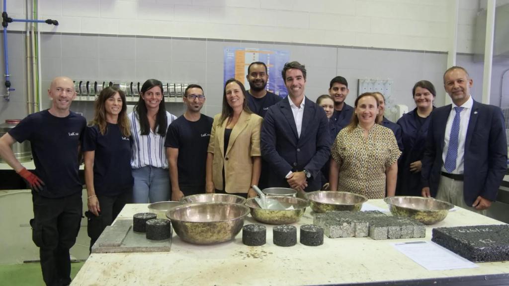 Los investigadores junto con trozos del asfalto hecho de colillas de cigarrillos.