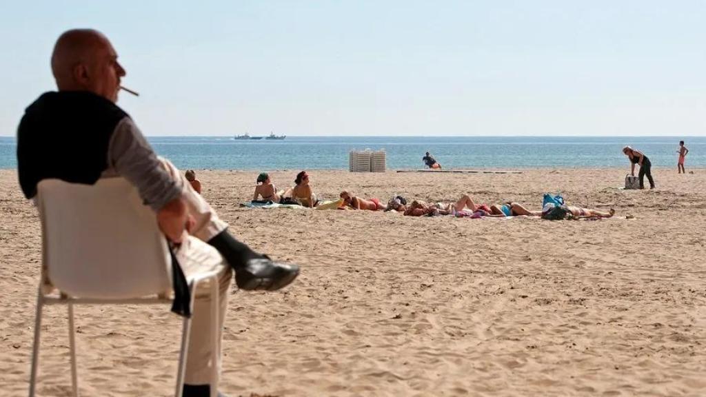 Un hombre fuma un cigarrillo en la playa de Las Arenas, en Valencia, en una imagen de archivo.