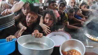 Palestinos acuden a las colas del hambre para recoger comida.