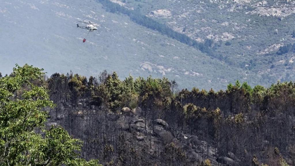 Un helicóptero de los bomberos trata de controlar el fuego declarado este martes por Mombentrán (Ávila).