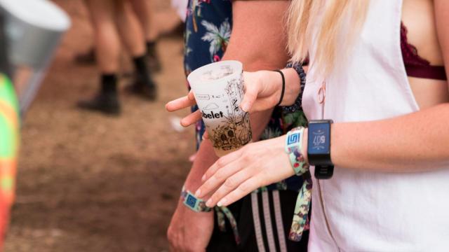 Una mujer con una bebida en un festival de música.