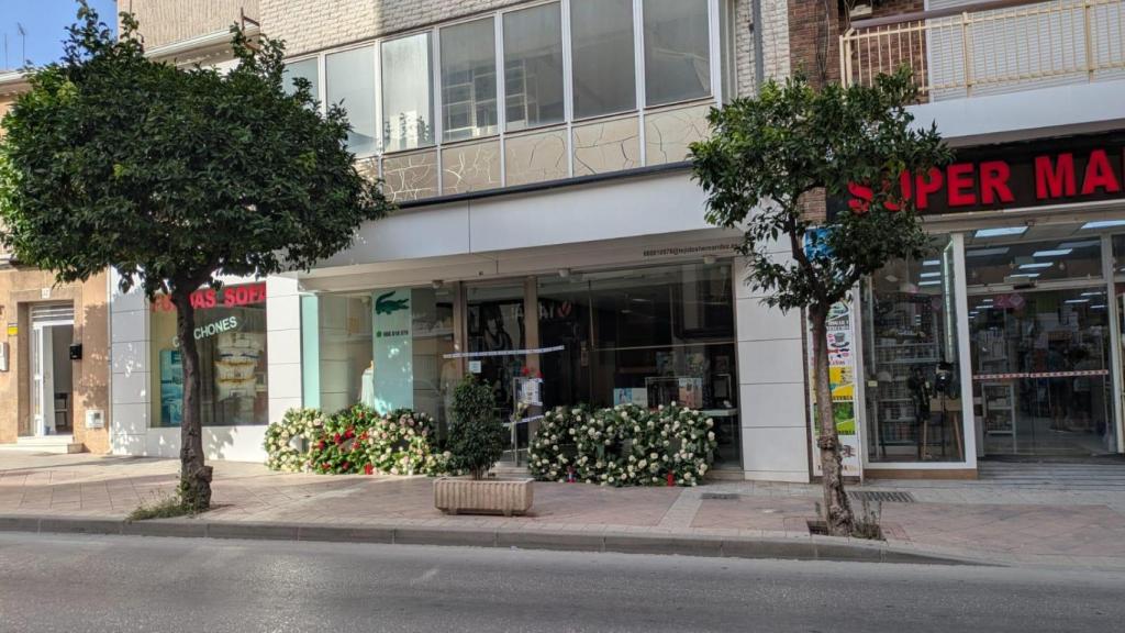 Coronas de flores que los vecinos de Molina de Segura han dejado en la fachada de Tejidos Hernández como homenaje a Felipe.