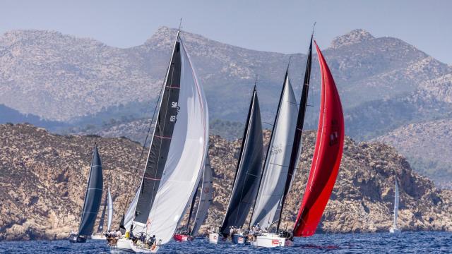Flota de Sail Racing ORC A navegando con la costa mallorquina de fondo.