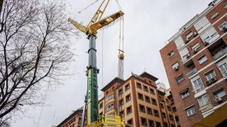 Imagen de archivo de una grúa junto a un edificio