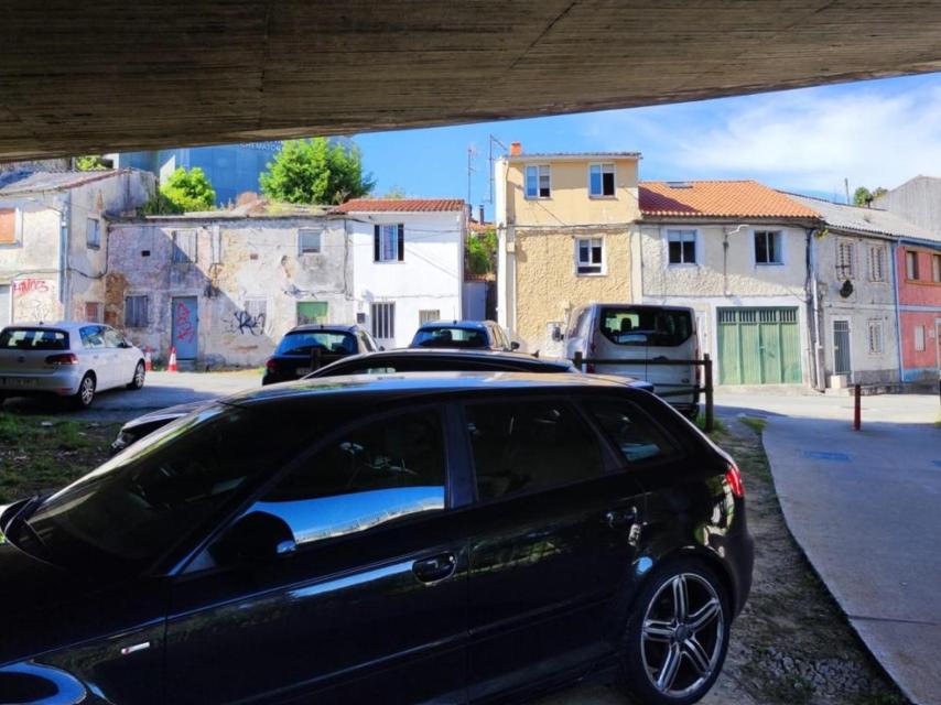 Coches bajo la avenida de A Pasaxe y frente a casas de As Xubias de Arriba.