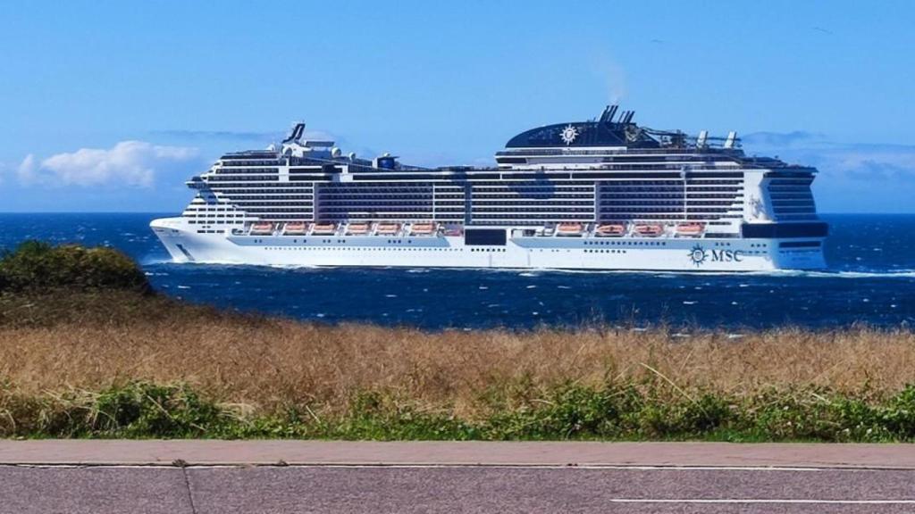 Un crucero abandona A Coruña, a la altura de la Torre de Hércules.