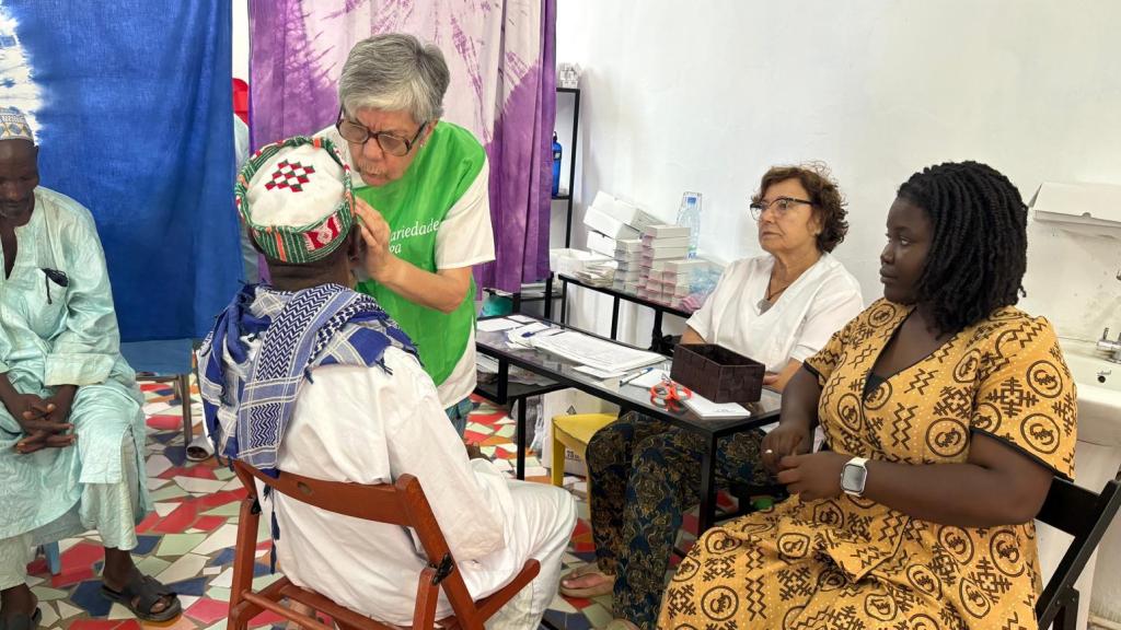 Fina Pombo atiende a un paciente durante su estancia de cooperante en Senegal acompañada de Fina Rodríguez y una traductora local.