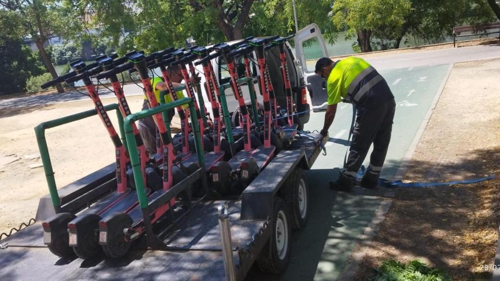 Operarios municipales retirando los patinetes eléctricos Voi.