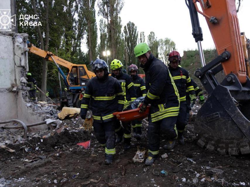 Los servicios de emergencia de Ucrania con uno de los cadáveres recuperados tras un ataque contra Kiev.