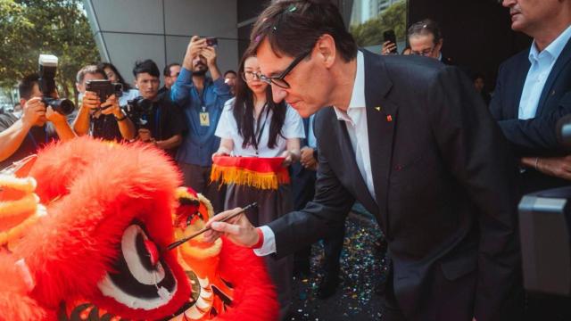 El president Illa pinta sobre un dragón, el viernes durante una visita a una planta de componentes para automóviles, en Shanghái.