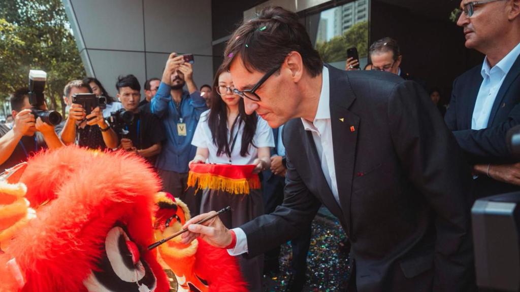 El president Illa pinta sobre un dragón, el viernes durante una visita a una planta de componentes para automóviles, en Shanghái.