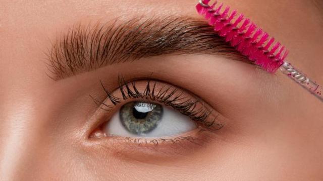 Mujer maquillándose las cejas.