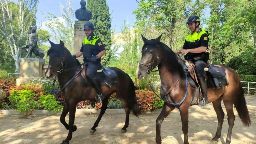 Dos agentes de la policía local montados sobre dos miembros del escuadrón, en la plaza del Pilar de Zaragoza.