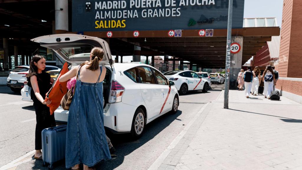 Unas mujeres cargan su equipaje en un taxi en la estación de Atocha de Madrid.